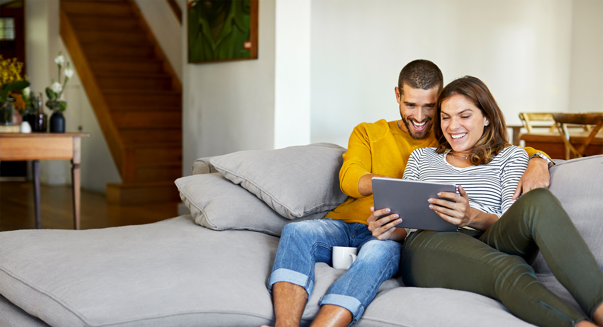 Paar sitzt mit Tablet auf einem Sofa